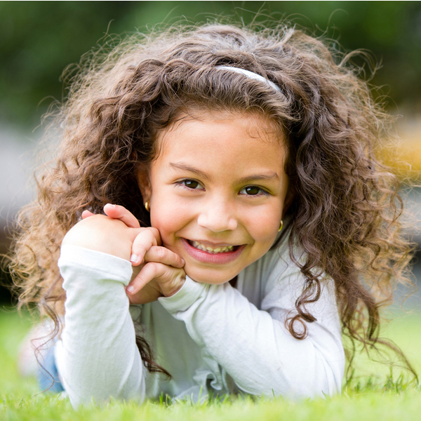 Special Needs Dentistry Young Girl Laying in Grass